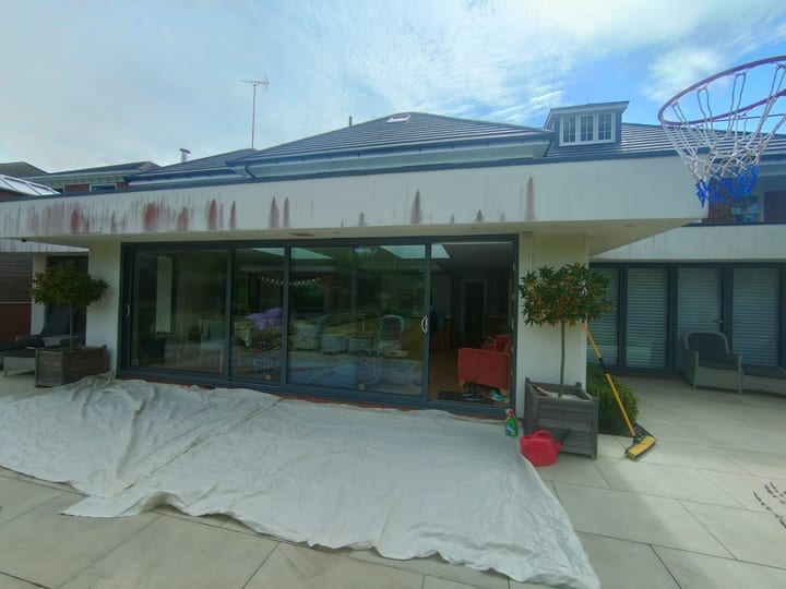 Weathered residential render before preparation and painting